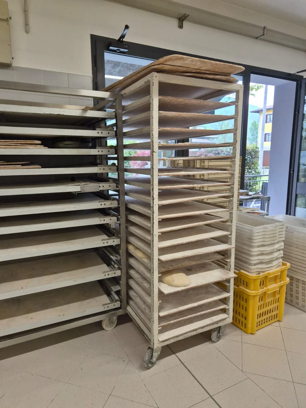 Carrelli con vassoi di legno per la lievitazione del pane